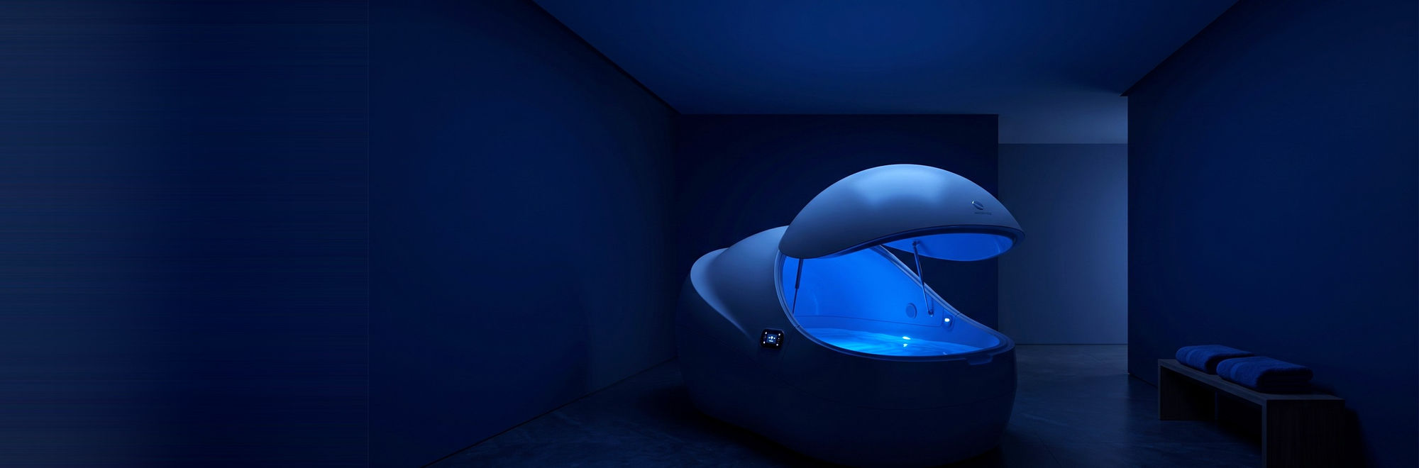Float pod (floatation tank) glowing softly blue at Float Therapy Wilmslow